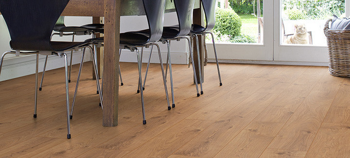 Das Esszimmer ist mit Laminat in hellem Holzfarbton ausgelegt. Ein massiver Esstisch aus Holz und leichte Stühle runden die Einrichtung ab.