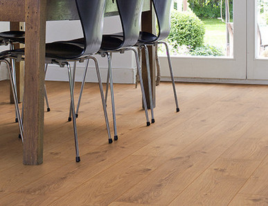 Das Esszimmer ist mit Laminat in hellem Holzfarbton ausgelegt. Ein massiver Esstisch aus Holz und leichte Stühle runden die Einrichtung ab.