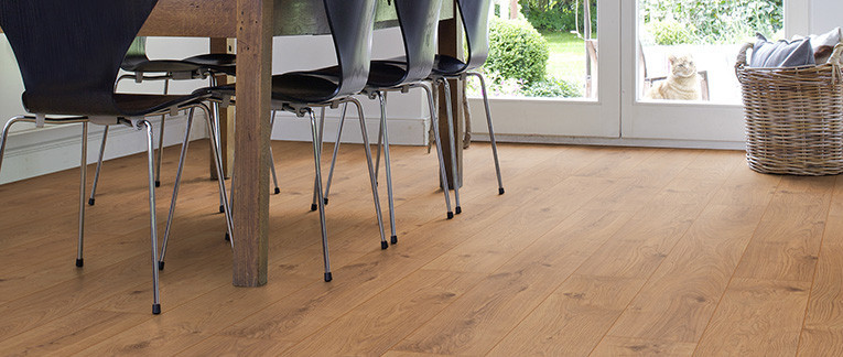 Das Esszimmer ist mit Laminat in hellem Holzfarbton ausgelegt. Ein massiver Esstisch aus Holz und leichte Stühle runden die Einrichtung ab.